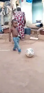 Child plays soccer in a rustic yard.