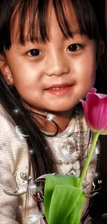 Portrait of smiling child with pink tulip.