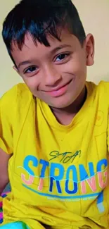 Child smiling in bright yellow shirt, cheerful mood.