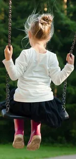 Child swinging with a forest backdrop.