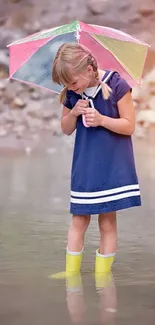 Young girl with colorful umbrella in a creek.