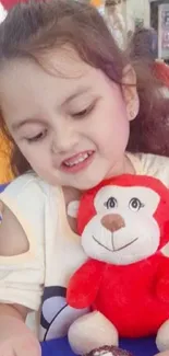 Child smiling with red monkey toy, vibrant colors.