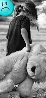 Black and white image of a child holding a large teddy bear.