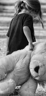 Black and white image of a child with a large toy lion.