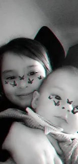 Monochrome photo of two children with butterfly face art.