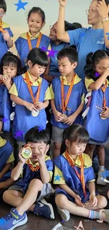 Children in blue uniforms with medals at a celebratory event.