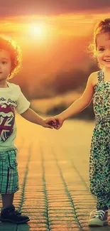 Two smiling children hold hands at sunset on a path.