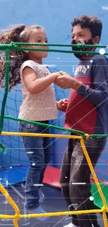 Children playing joyfully inside a colorful net structure.