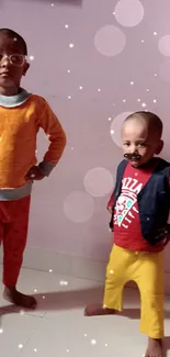 Two children pose in colorful outfits on a light pink background.