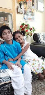 Smiling children sitting on a patterned sofa in a cozy living room.