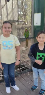 Children at a bird exhibit with green parrot.