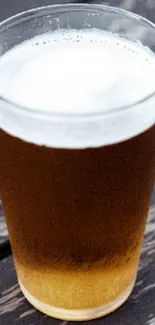 Chilled glass of beer on a wooden table.