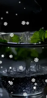 Chilled mint glass with ice and snowflakes on dark background.