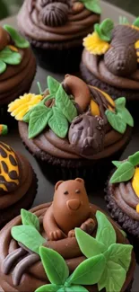 Chocolate cupcakes with colorful animal designs and fondant art.