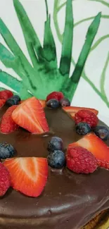 Chocolate cake with berries and green leaves backdrop.