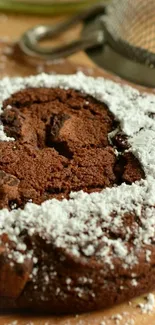 Close-up of a chocolate cookie with icing sugar dusting.