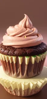 Chocolate cupcake with pink frosting on a stand.