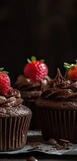 Chocolate cupcakes with strawberries on top in a rich, dark setting.