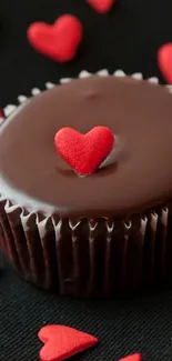 Chocolate cupcake with heart-shaped topper on black background.