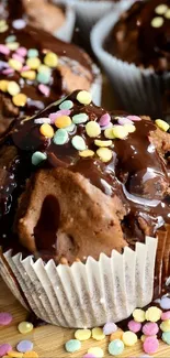 Chocolate cupcakes with colorful sprinkles on a wooden table.