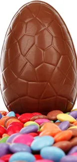 Chocolate egg with colorful candy backdrop.