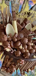 Delicious birthday chocolate cake decorated with various chocolates.
