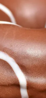 Close-up of a chocolate glazed donut with white icing spirals.