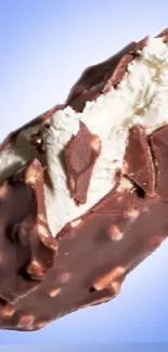 Chocolate ice cream bar with vanilla filling and blue background.
