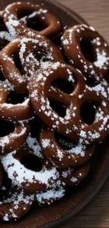 Chocolate pretzels with powdered sugar on a wooden plate.
