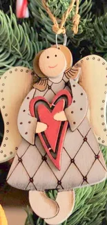 Charming Christmas angel ornament with heart, set against festive greenery.