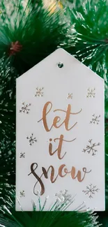 'Let It Snow' tag on green pine branches.