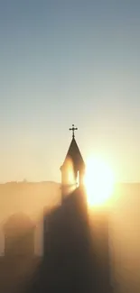 Church silhouette with sunrise backdrop, serene morning view.