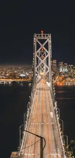 Beautifully lit urban bridge leading to a vibrant city skyline at night.