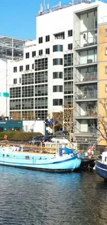 Boats on a city canal with modern buildings in the background.