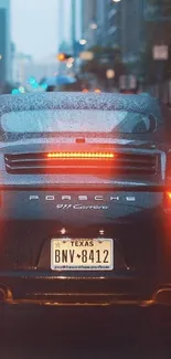 Sleek Porsche driving on a rainy city street, perfect for mobile wallpaper.