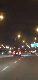 Nighttime highway with glowing streetlights and cars.