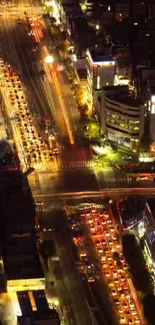 Aerial view of a bustling city at night with illuminated streets and buildings.