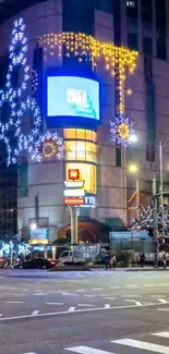 Festive city street at night with holiday lights and decorations.