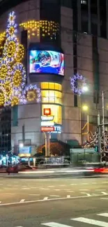 Illuminated urban street with festive lights and decorations.