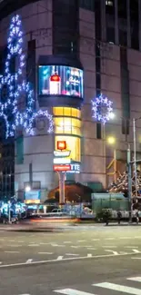 City street adorned with holiday lights and decorations at night.