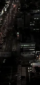 Aerial nighttime view of a vibrant, lively city street with bright lights.