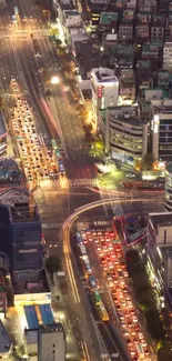 Aerial view of a city at night with bright lights and busy roads.