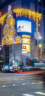 Night view of city building with festive lights and traffic.