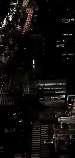 Aerial view of a city street at night with bright lights and traffic.