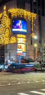 Night cityscape with bright holiday lights on urban building and streets.