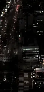 Aerial view of city streets at night with vibrant lights and bustling traffic.