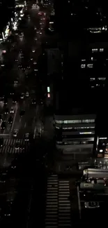 Aerial view of a vibrant city street at night with lights and traffic.