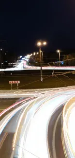 Night city traffic with vibrant light trails under a dark blue sky.