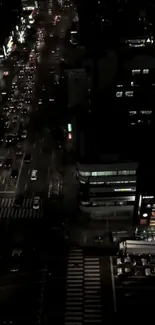 Aerial view of a city street at night with busy traffic and vibrant lights.