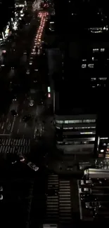 Aerial view of a busy city street at night with vibrant traffic lights.